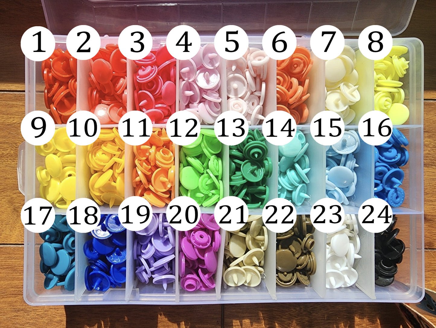 les 24 boutons pressions au choix numérotés pour en choisir un pour la pochette à livre écaille de dragon.