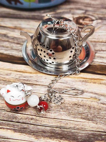 Infuseur à thé Manekineko posé sur une table 