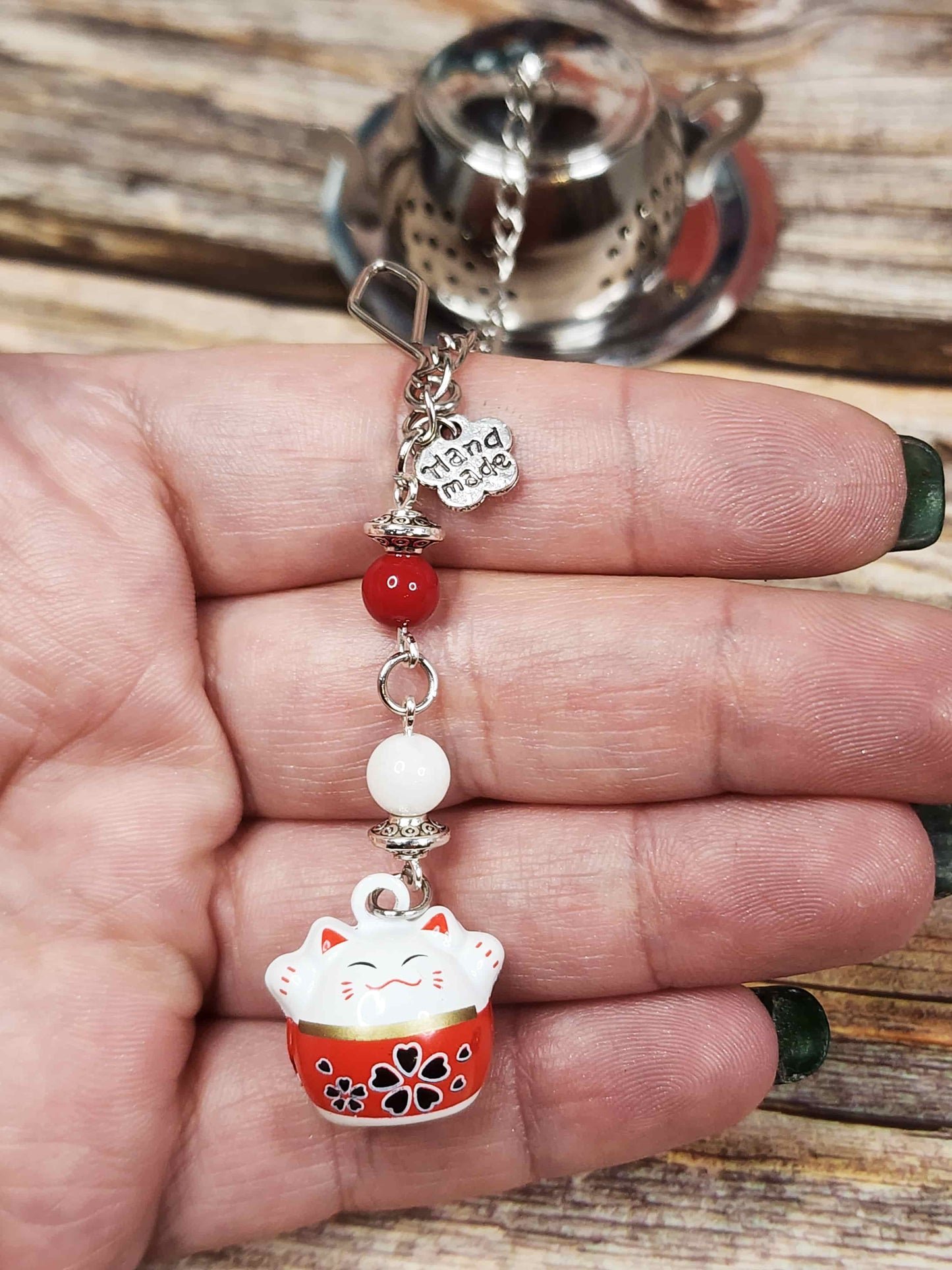 zoom sur la clochette maneki neko et sur les pierres fines dans ma main