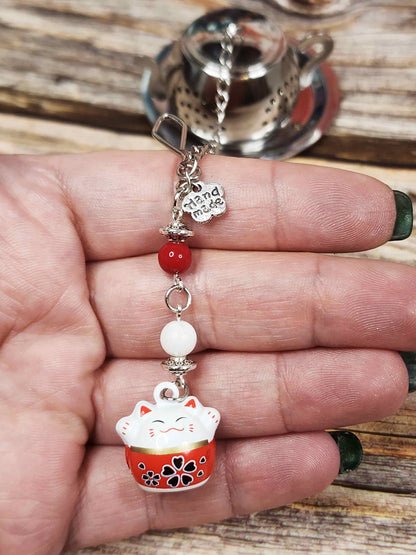 zoom sur la clochette maneki neko et sur les pierres fines dans ma main